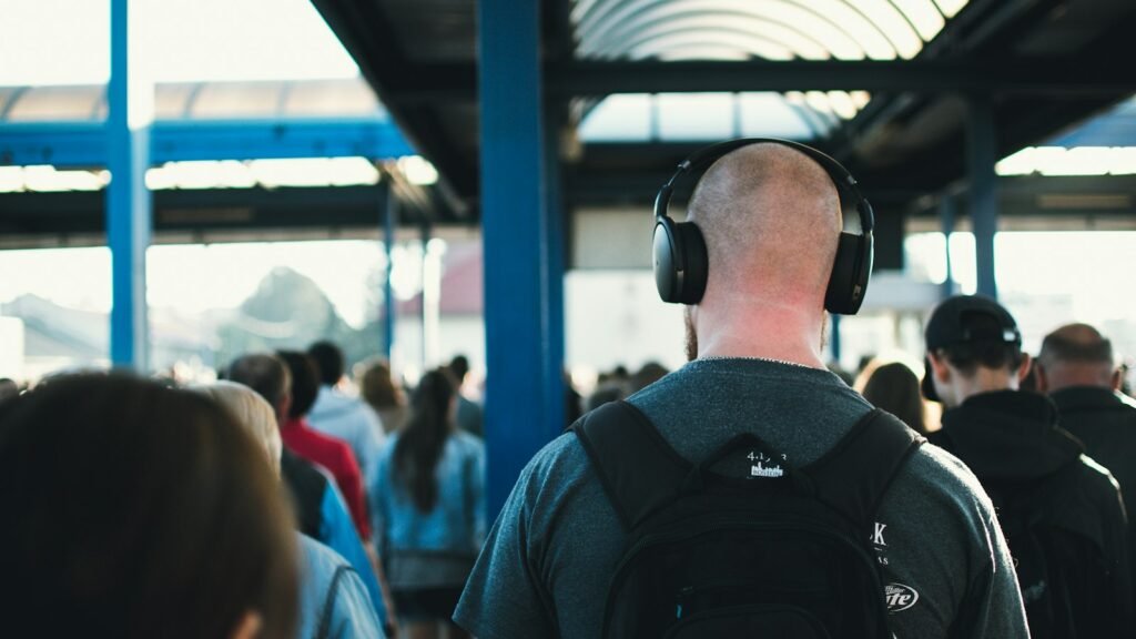 Homme marchant avec un casque sans fil dans la foule